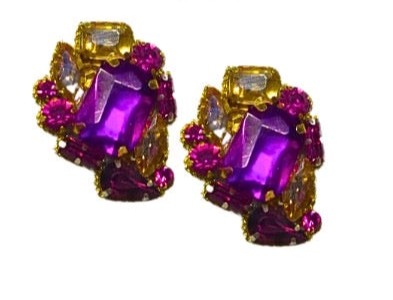 Pair of earrings with purple gemstones and gold accents on a white background